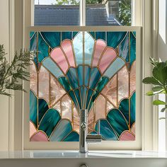 a bathroom window with an art glass design in the middle and potted plants on the side