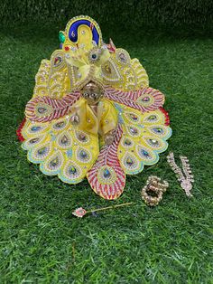 an idol sitting in the grass next to some beads