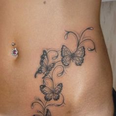 a close up of a woman's stomach with butterfly tattoos on her belly and side