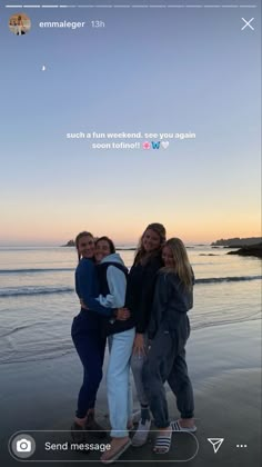 three women are standing on the beach at sunset with their arms around each other and smiling