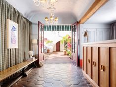 an entry way leading into a house with wood paneling and tile flooring on both sides