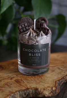 a glass jar filled with chocolate and marshmallows on top of a wooden table