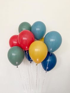 a bunch of balloons floating in the air on top of a cake plate with candles