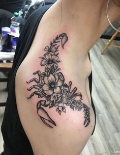 a woman's breast with flowers and an umbrella tattoo on her left side ribcage