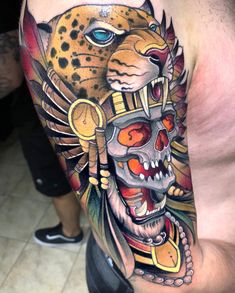 a man with a tattoo on his arm that has a tiger and skull on it