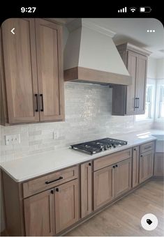 a kitchen with wooden cabinets and white counter tops in front of a stove top oven