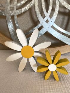 two wooden flowers sitting next to each other on a table