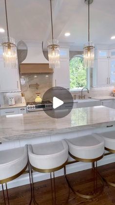 a kitchen with marble counter tops and white stools