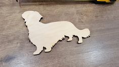 a wooden cutout of a dog sitting on the floor next to a banana peel