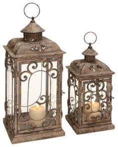 two metal lanterns with candles in them