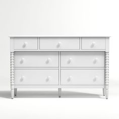 a white dresser with drawers and knobs on it