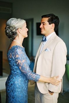 a man and woman standing next to each other in front of a tv screen, smiling at each other