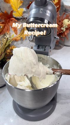 a metal bowl filled with whipped cream on top of a counter next to a blender