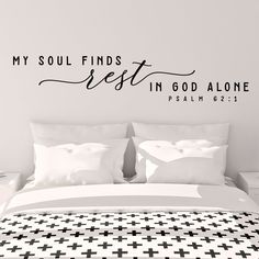 a bedroom with a bed and wall decal that says, my soul finds rest in god alone