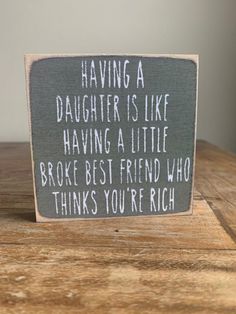 a sign that says having a daughter is like having a little broke best friend who thinks you're rich