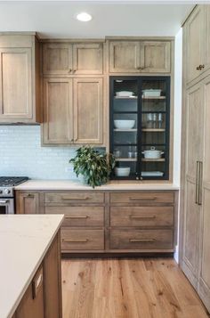 a kitchen with wooden cabinets and white counter tops