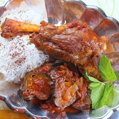 a plate with meat, rice and mint garnishes