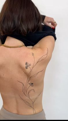 the back of a woman's body with tattoos on her upper and lower back