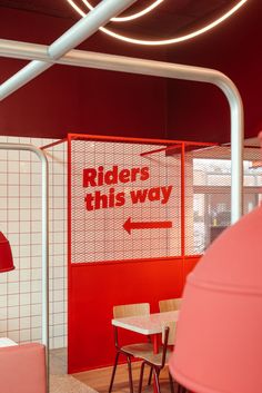 a red and white room with a sign that says riders this way