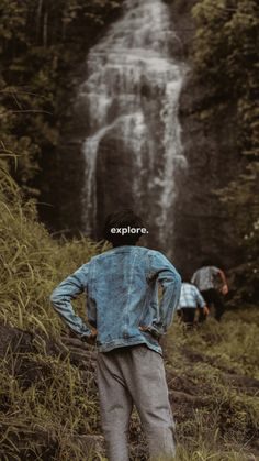 two people standing in front of a waterfall