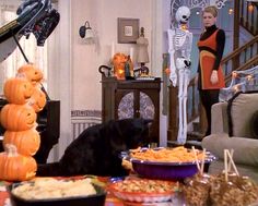 a black dog sitting in front of a table filled with halloween treats and candy bars