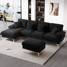 a living room with a black couch and ottoman