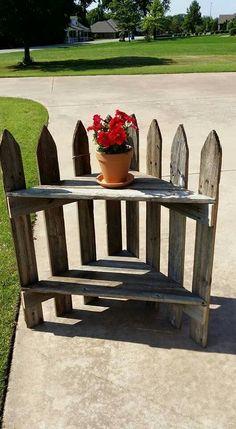 a potted plant sitting on top of a wooden bench next to a cement walkway