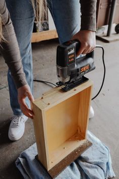 a person using a power drill to attach a piece of wood with a sanding machine