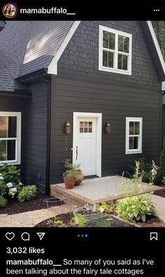 a black house with white trim and two windows on the front door is featured in an instagram