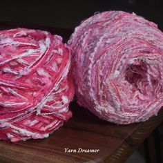 two balls of yarn sitting on top of a wooden table