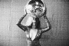 a woman holding a disco ball over her head