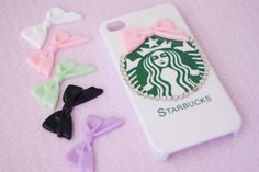 there is a starbucks phone case with bows and hair clips next to it on the table