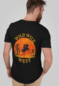 Saddle up for style with our Wild West Cowboy Shirt! Perfect for rodeos, country music concerts, and festivals, this versatile Western tee is a must-have for any cowboy or cowgirl's wardrobe. Key Features: Classic unisex design Soft, lightweight 100% Airlume combed and ring-spun cotton Breathable fabric  Ribbed knit collar for durability Tapered shoulders for improved fit Dual side seams for shape retention Tear-away label to prevent skin irritation Perfect for: ✓ Rodeo events ✓ Country music concerts ✓ Western-themed parties ✓ Casual everyday wear ✓ Line dancing nights This high-quality cowboy shirt offers both comfort and style. The retail fit is ideal for casual and semi-formal settings, while the crew neckline provides a classic look. Ethically Made: Our shirts are manufactured by Bell Black Western Style Cotton T-shirt, Black Cotton Western T-shirt, Black T-shirt With Graphic Print For Rodeo, Black Graphic Print T-shirt For Rodeo, Black Western Top With Graphic Print, Black Western Style T-shirt For Rodeo, Black Graphic Print Top For Rodeo, Cowgirl T Shirt, Cowboy Clothes