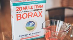 a box of borax next to a glass measuring cup on a wooden table