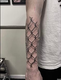 a man's arm with barbed wire on the wrist and hand tattoo design in black ink