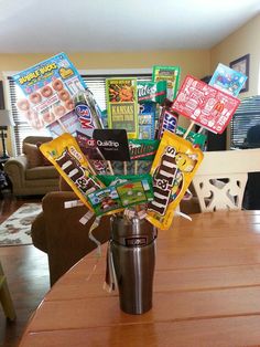 a coffee cup filled with candy bars on top of a wooden table