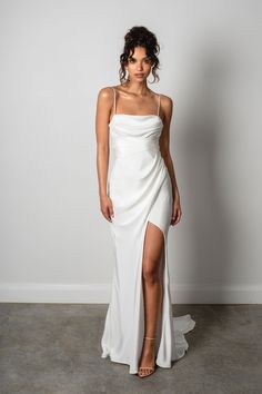 a woman wearing a white dress with a slit in the side