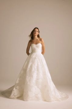 a woman in a white wedding dress posing for the camera with her hands on her hips