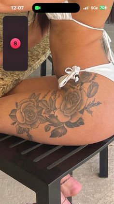 a woman is sitting on a bench with her legs crossed and showing off her tattoos