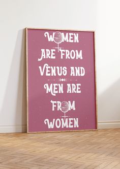 there is a pink poster on the floor in front of a wall that says women are from venus and men are from women