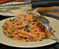 a white plate topped with pasta and parmesan cheese