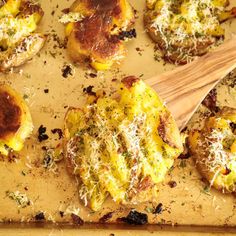 some food that is sitting on a cutting board with a wooden spatula next to it