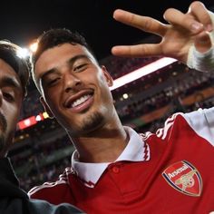 two men standing next to each other at a soccer game