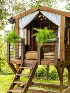 a wooden structure with plants in it and stairs leading up to the top floor area