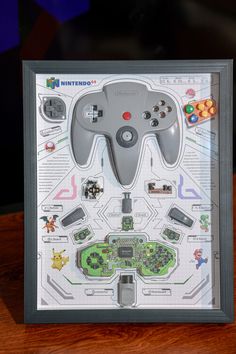 a nintendo wii game controller in a shadow box