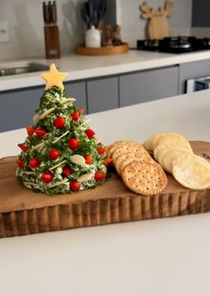 a christmas tree made out of cheese and crackers on a cutting board in a kitchen