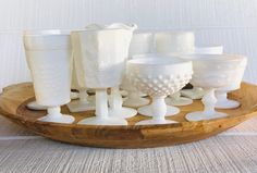 white glassware sitting on top of a wooden tray