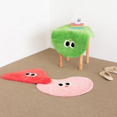 two pieces of furniture sitting on top of a floor next to each other with eyes painted on them