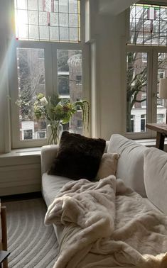 a white couch sitting next to a window in a living room