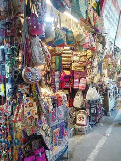 many bags and purses are on display at the market